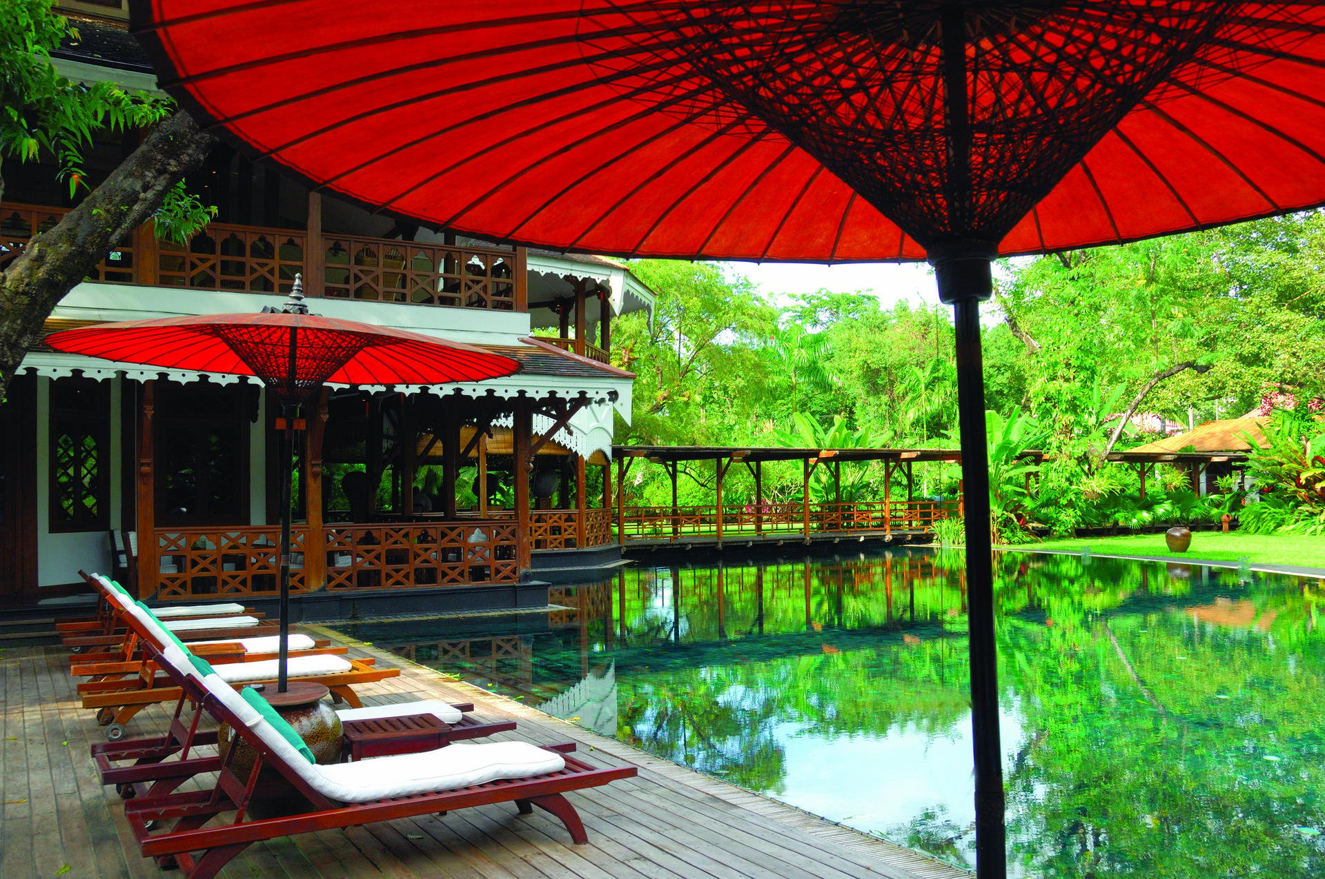 Teak furniture, lush foliage and relaxing poolside views complete the well-appointed quarters.