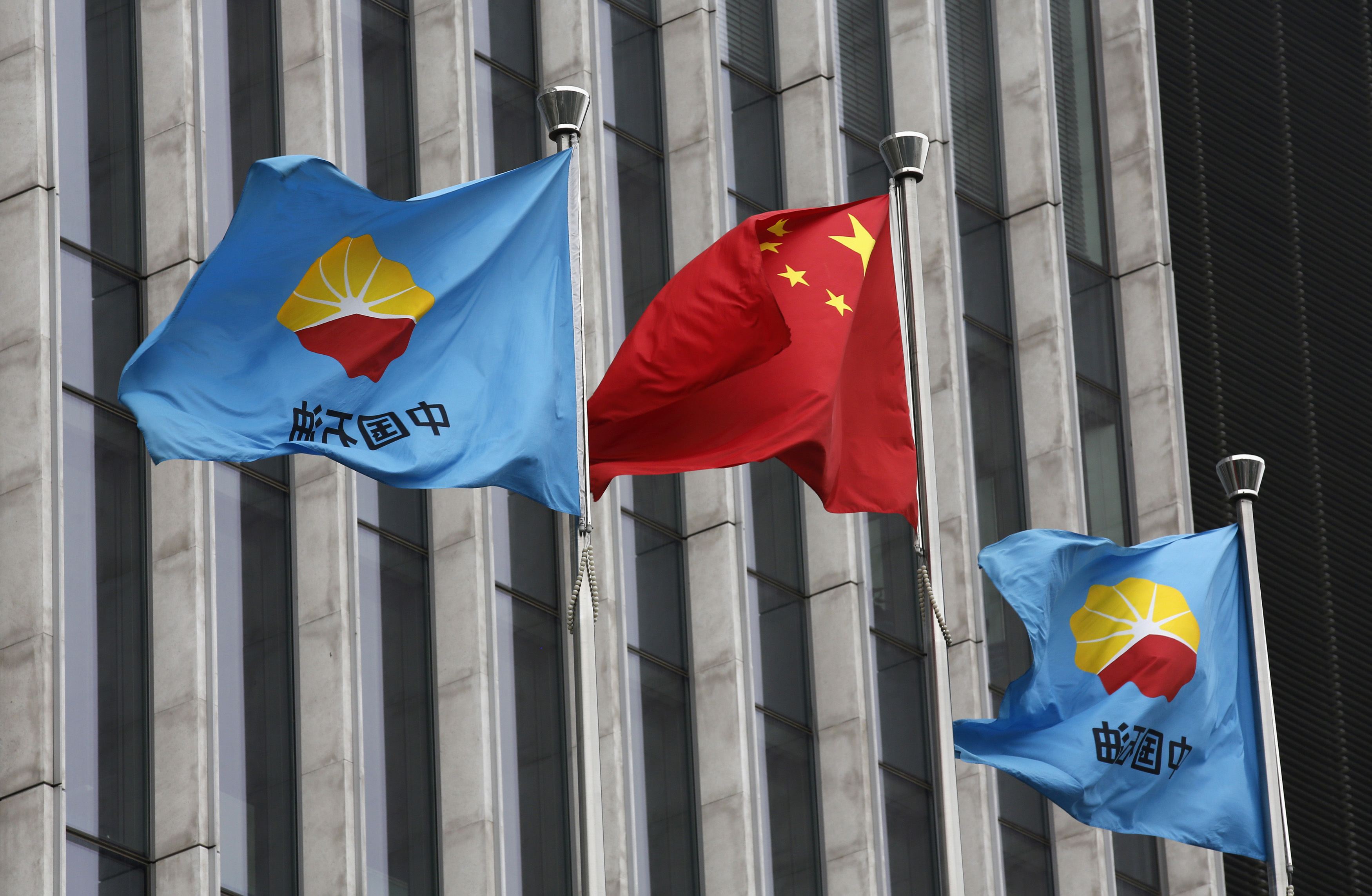 A Chinese national flag flutters between PetroChina's flags at headquarters in Beijing. Photo: Reuters