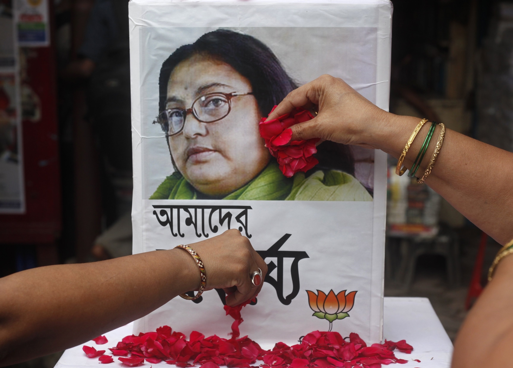Supporters of India's main opposition Hindu nationalist Bharatiya Janata Party (BJP) women's wing, scatter rose petals in front of a portrait of an Indian author Sushmita Banerjee, in Kolkata. Photo: Reuters