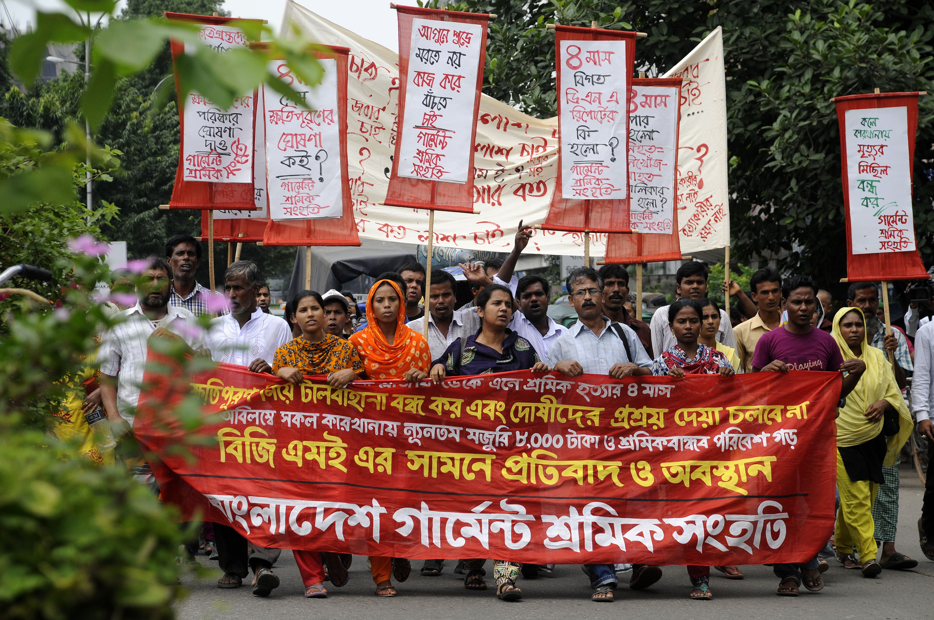 Garment workers shout slogans during An August 24 protest in Dhaka. Relatives of missing garment workers from the Rana Plaza collapse say they are still waiting for compensation four months after the accident. Photo: Xinhua