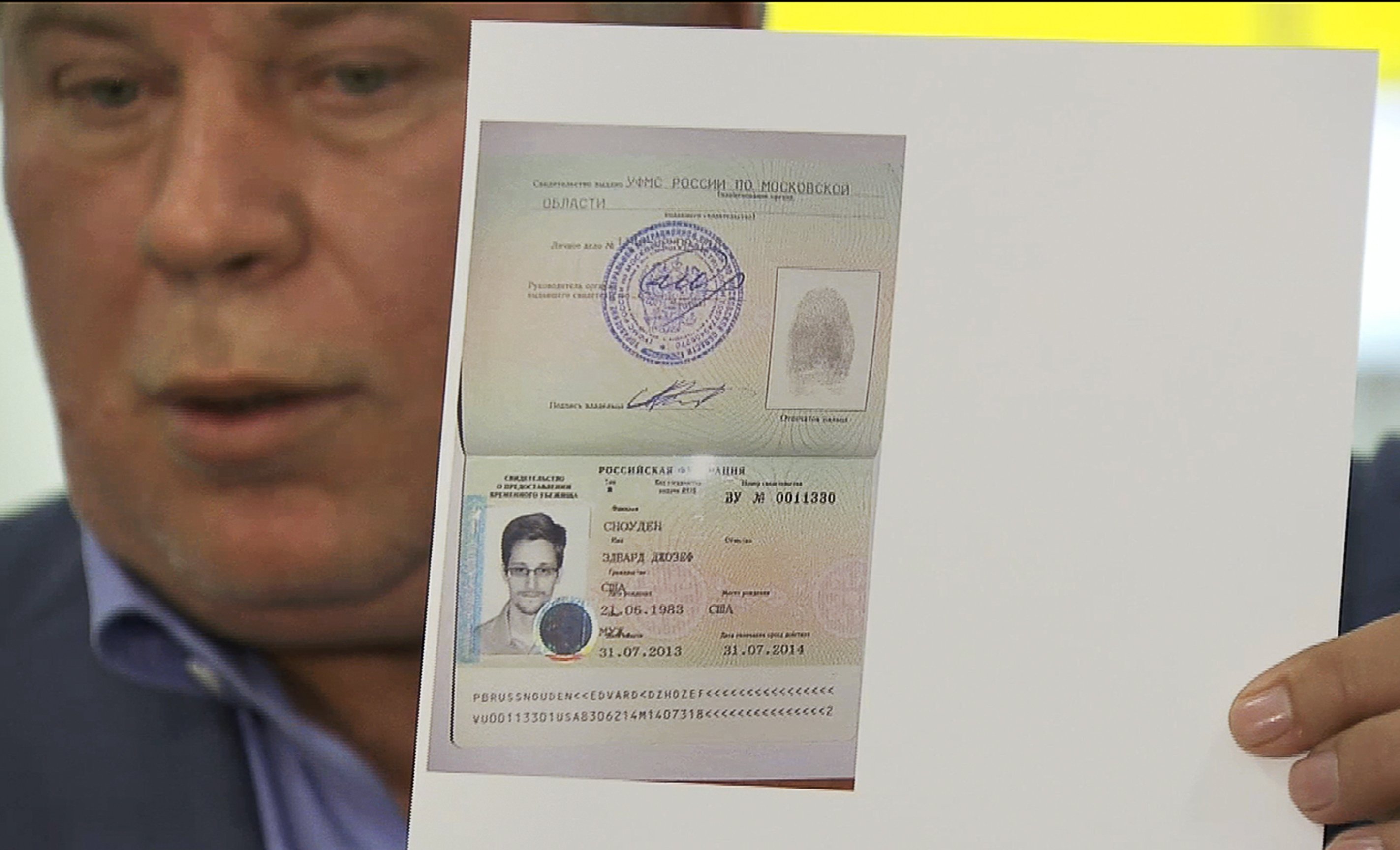 Russian lawyer Anatoly Kucherena showing a temporary document to allow Edward Snowden to cross the border into Russia. Photo: AP