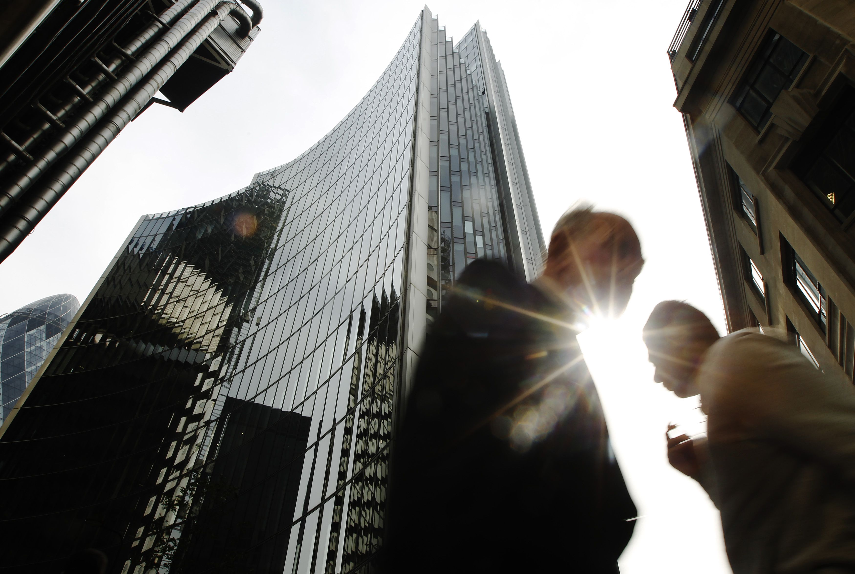 Pedestrians pass office blocks in the City of London June 19, 2013. Photo: Reuters