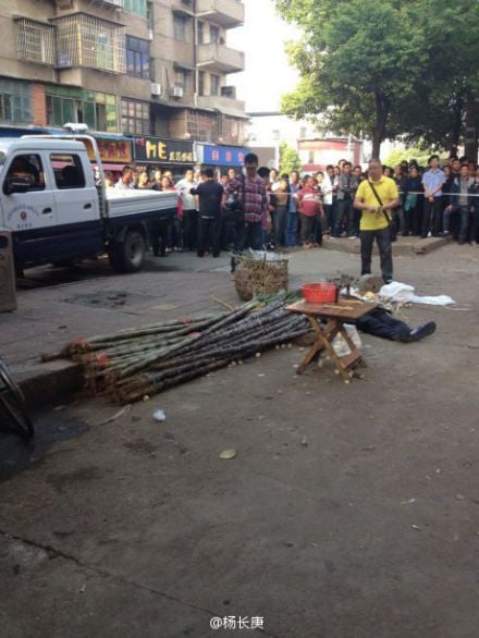 The body of Xu Lizhong seen lying amid onlookers in Yiyang, Hunan province, on Sunday. Screenshot via Sina Weibo. 