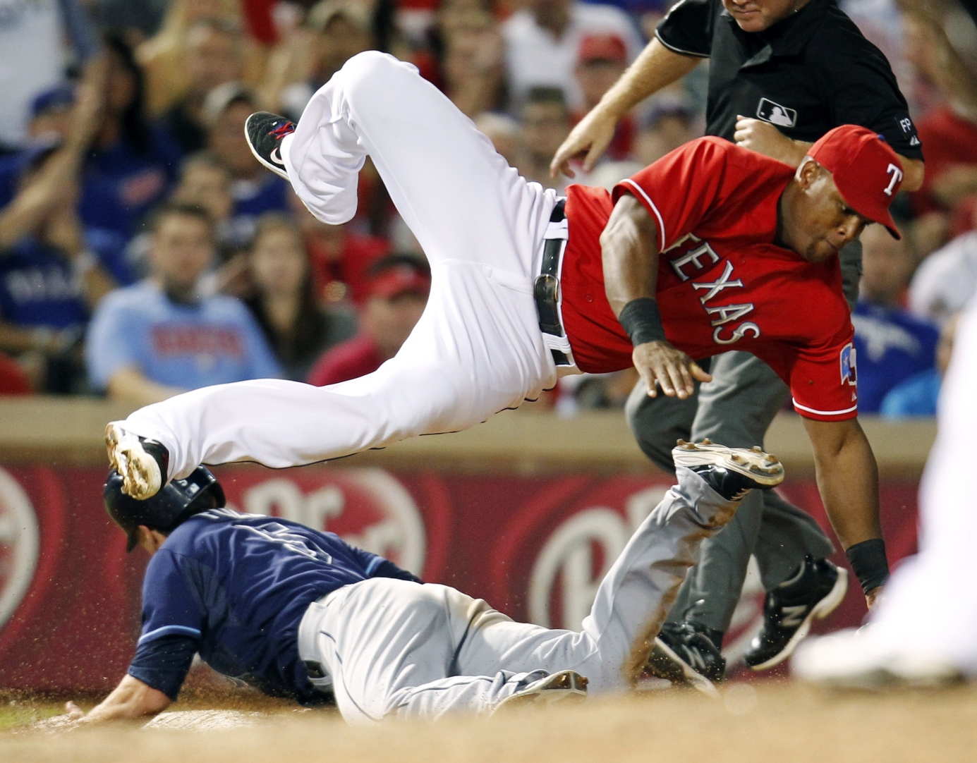 Tampa Bay Rays' Sam Fuld (left) steals third base as Texas Rangers' Adrian Beltre dives for a wild throw by Tanner Scheppers during their tiebreaker game on Monday. Photo: AP
