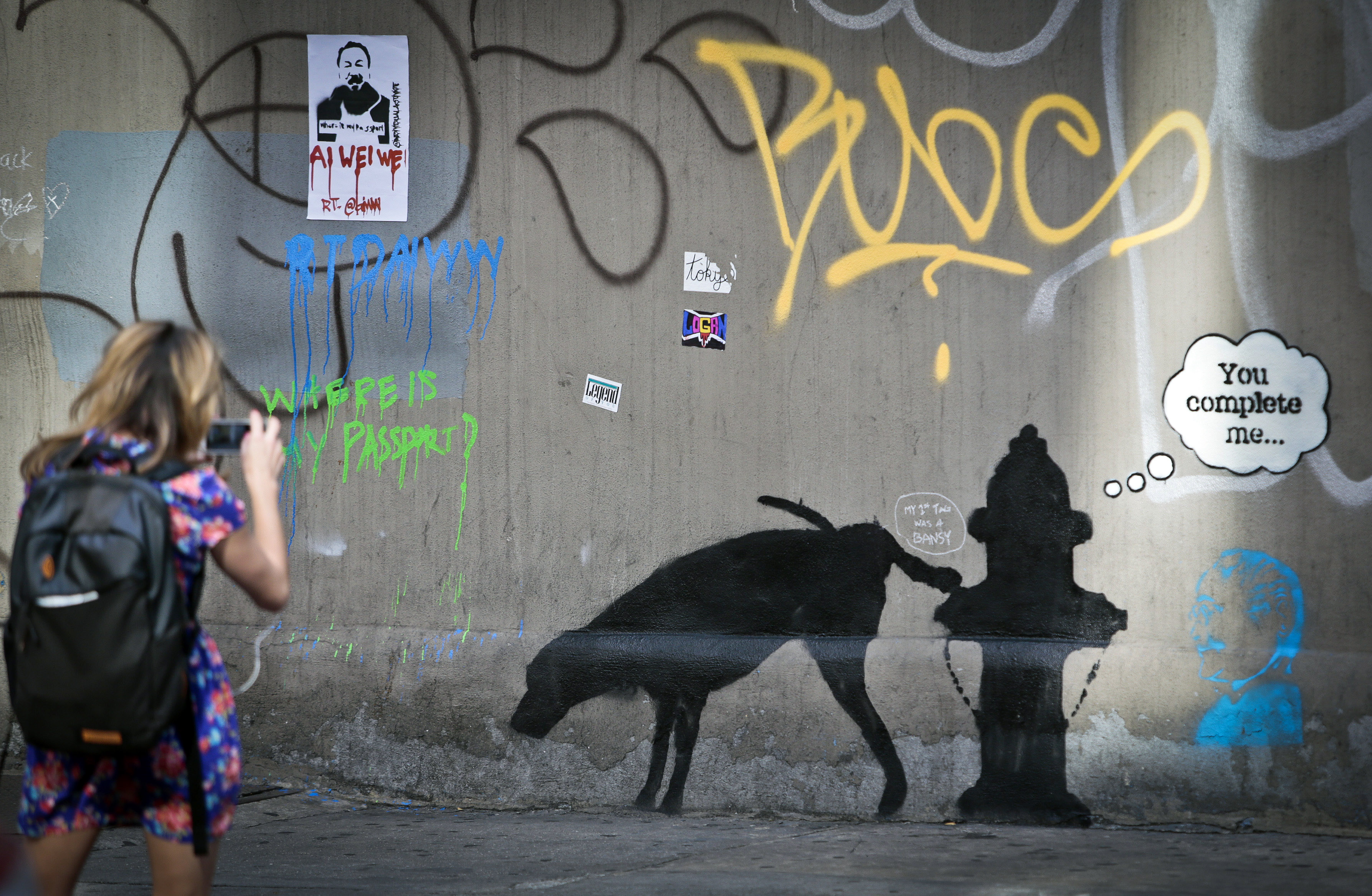 Graffiti by the secretive British artist Banksy, featuring a dog and a fire plug, draws attention on 24th Street, near Sixth Avenue in New York. Photo: AP