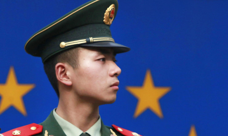 An officer guards the EU office in Beijing. The PBOC and ECB have signed a currency swap deal. Photo: AP