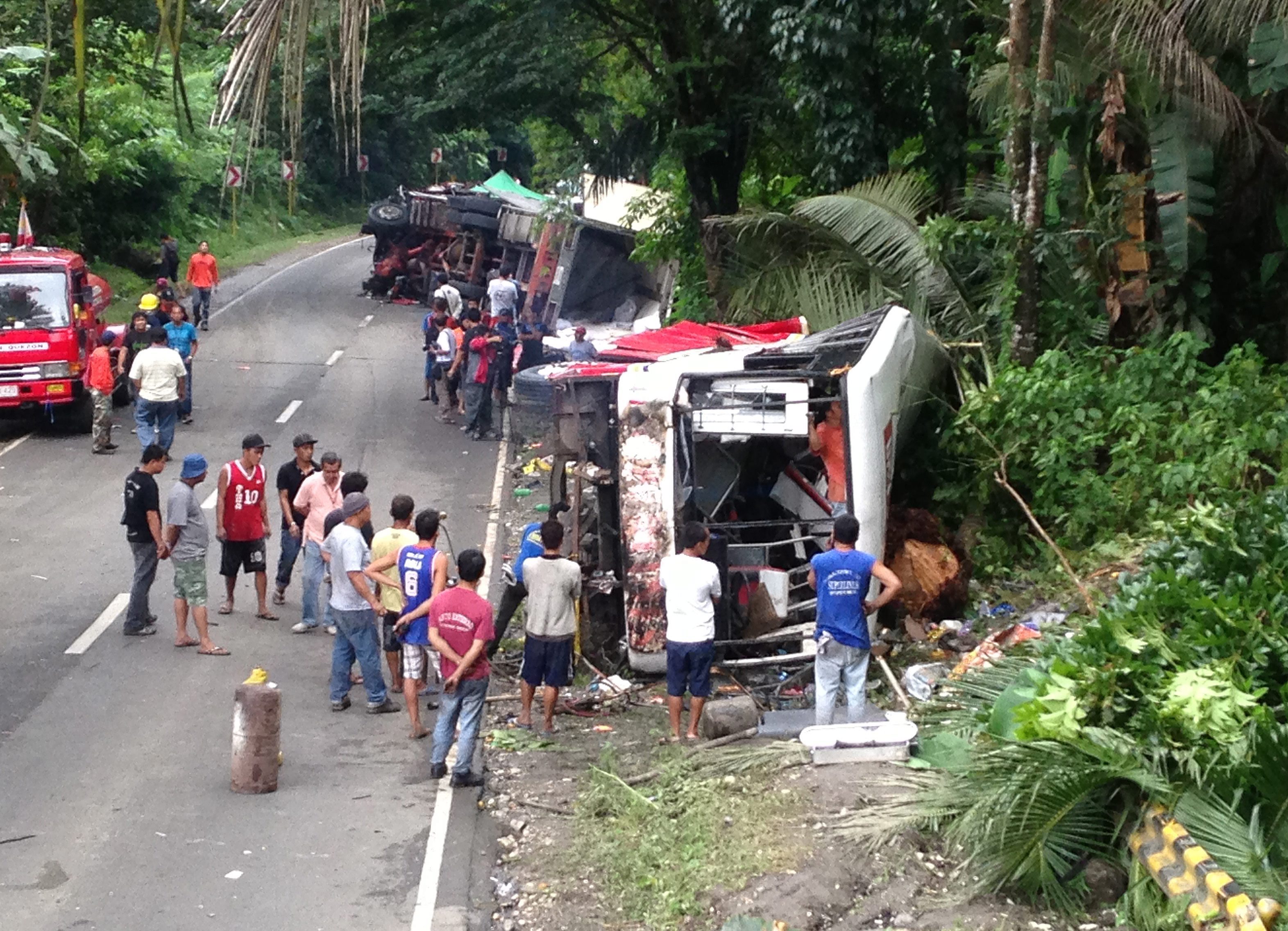 Filipino villagers view a wrecked passenger bus and a truck on a side of a road following an accident in the town of Atimonan, Quezon province, Philippines. Photo: EPA