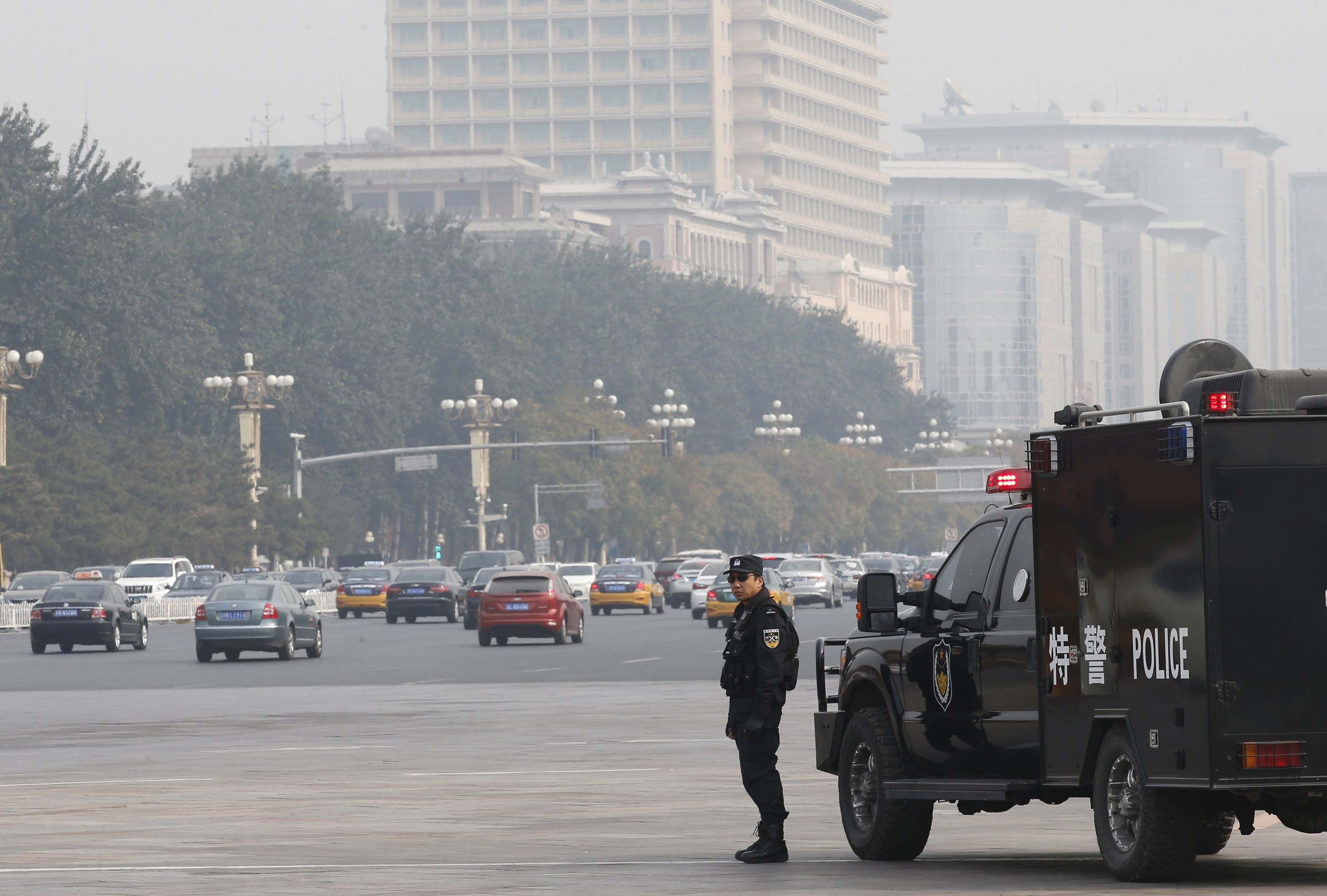 A policeman of the Special Weapons and Tactics team stands guard on a main street next to Tiananmen Square in Beijing. Photo: Reuters