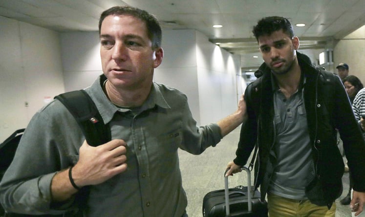 US journalist Glenn Greenwald walks with his partner David Miranda in Rio de Janeiro's International Airport. Photo: Reuters