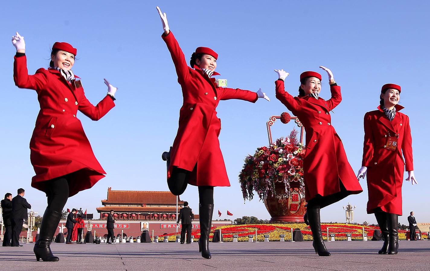 Female hotel attendants in red uniforms jump on Tiananmen Square in Beijing during the Communist Party's 18th Congress in November 2013. Photo: SCMP/Simon Song