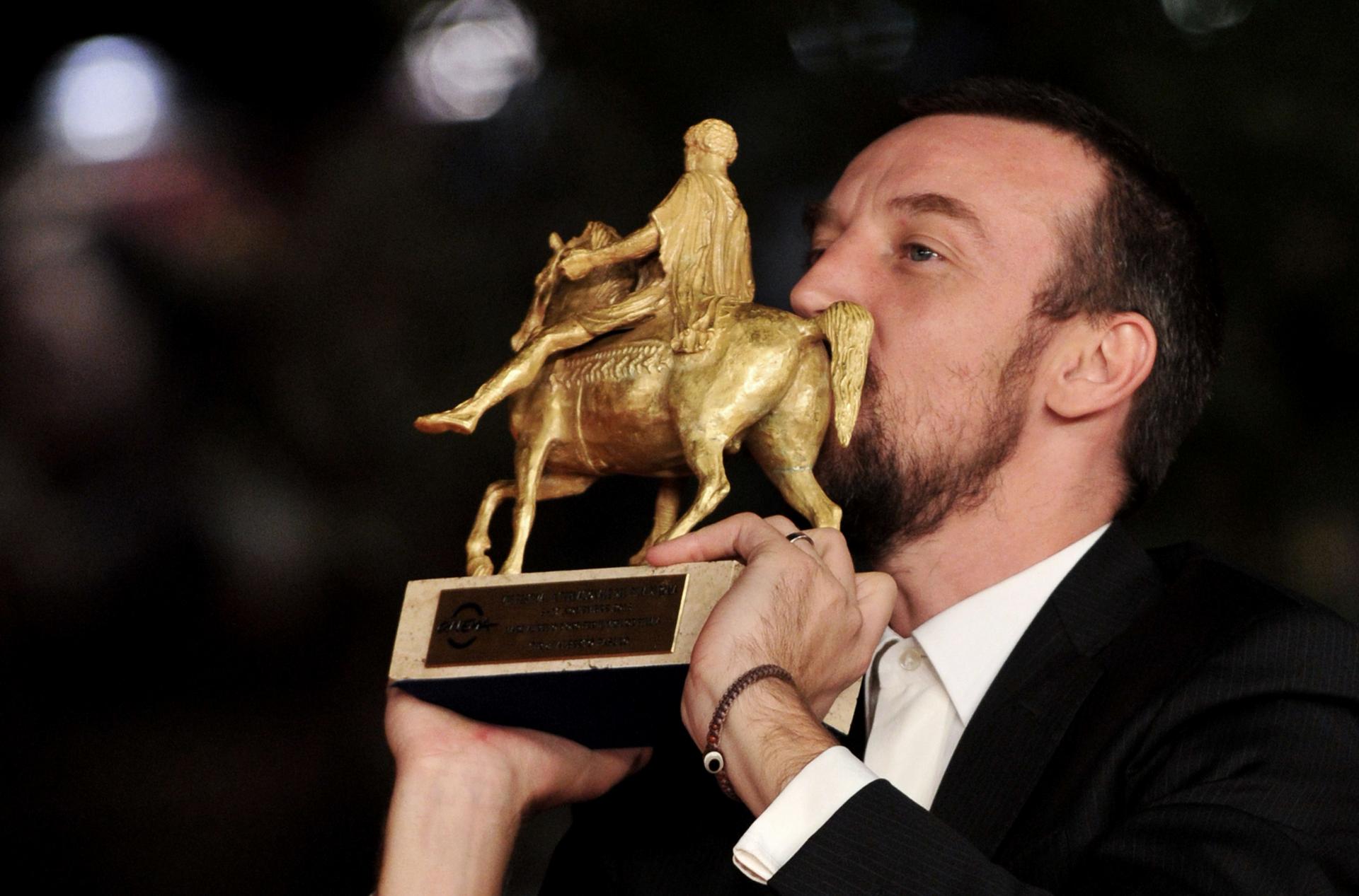 Director Alberto Fasulo kisses his best film award forTir. Photo: AFP