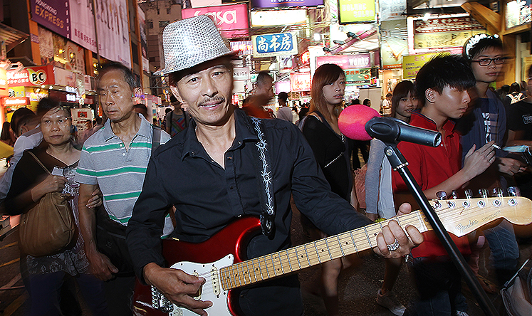 Lam Fat, lead singer of the band 3L, performs on Sai Yeung Choi Street South. Photo: Sam Tsang