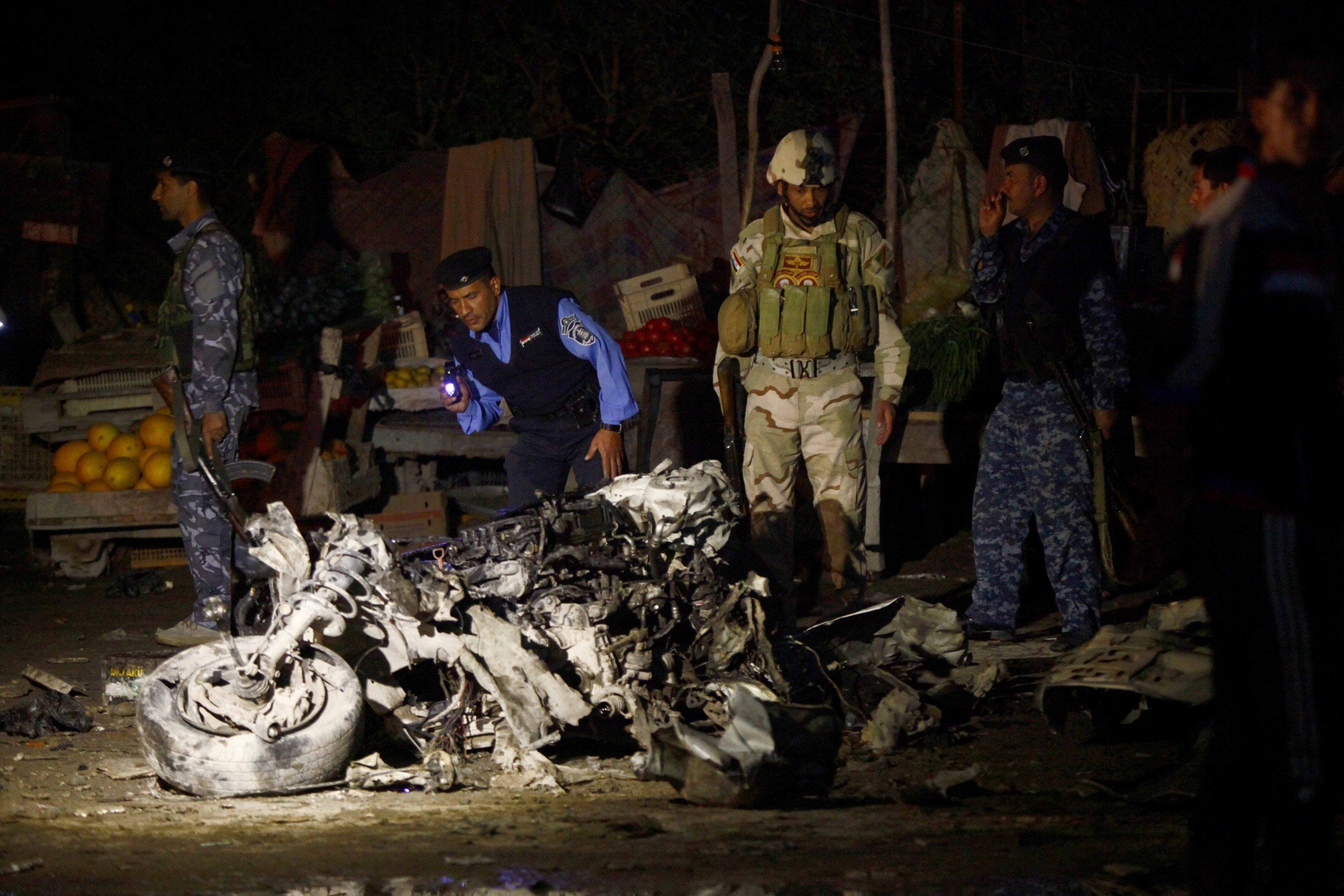 Iraqi security forces inspect the site of a car bomb attack. Photo: Reuters