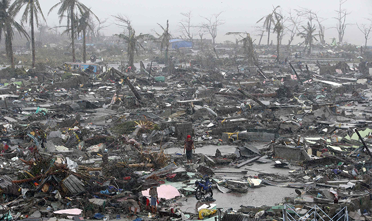 Survivors stand among debris and ruins of houses destroyed after Super Typhoon Haiyan battered Tacloban. Photo: Reuters