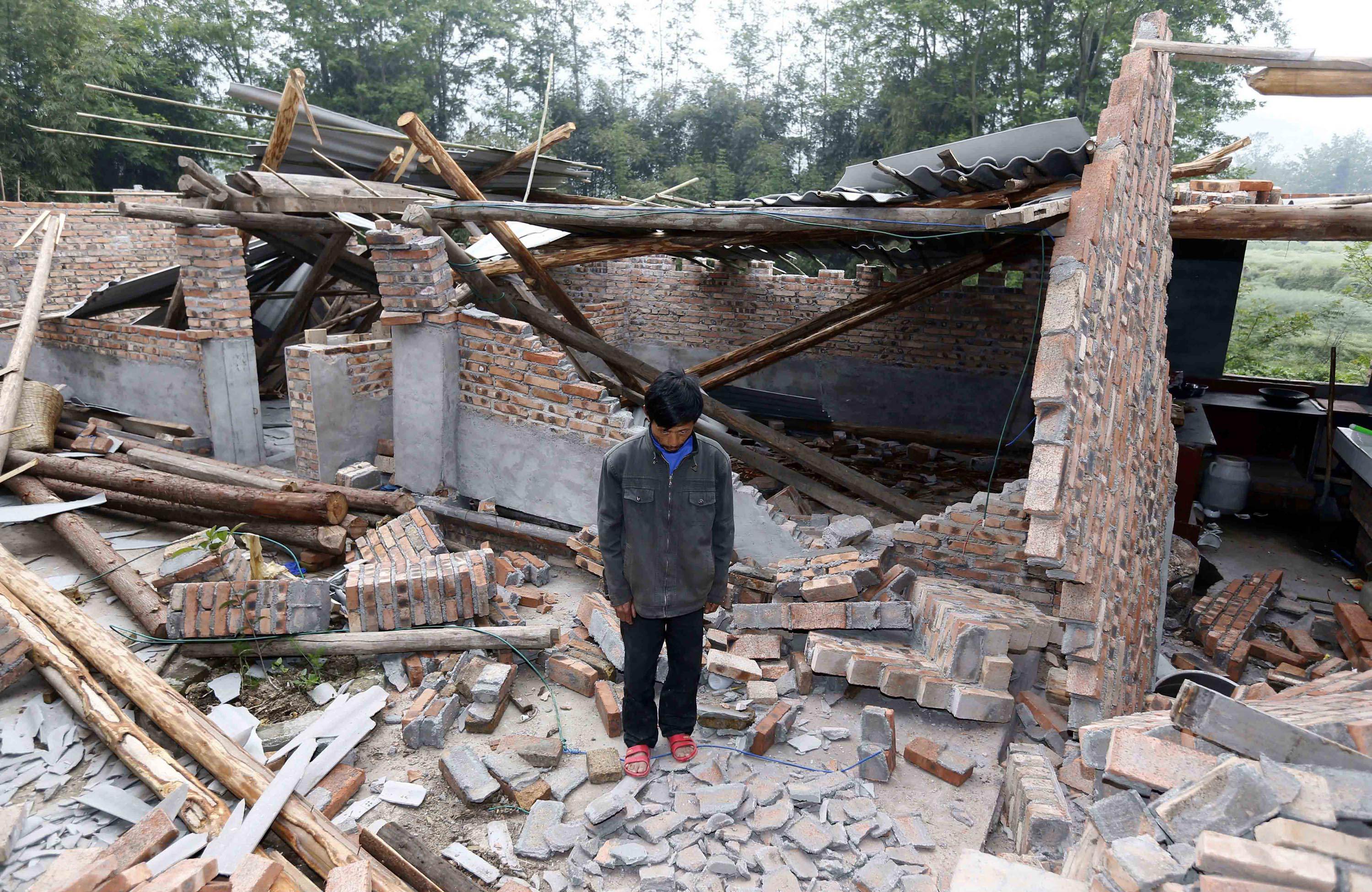 A local resident stands among the Yaan earthquake ruins in southwest China's Sichuan province. Photo: AFP