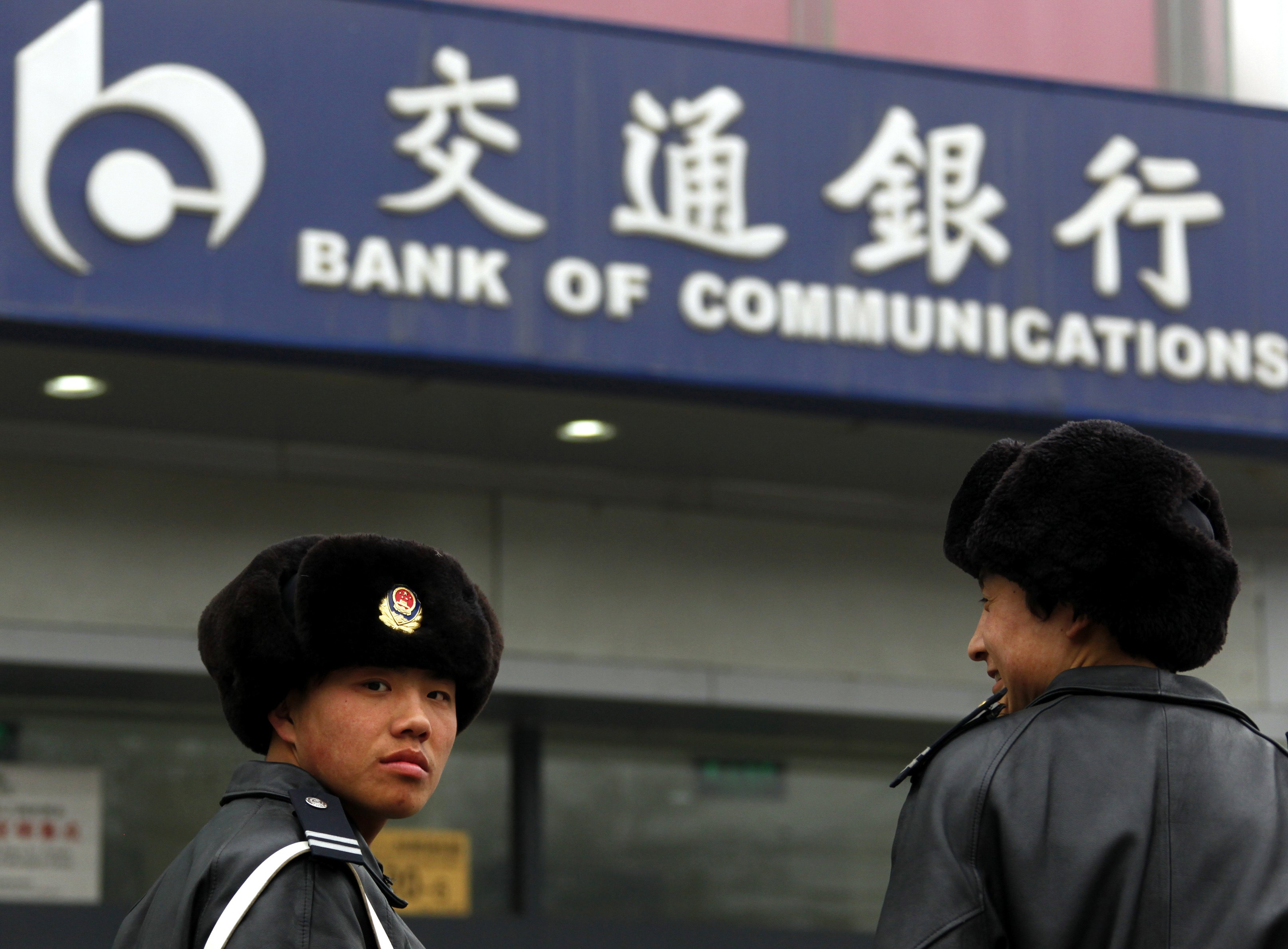 Security guards outside a branch of the Bank of Communications in central Beijing. Reuters