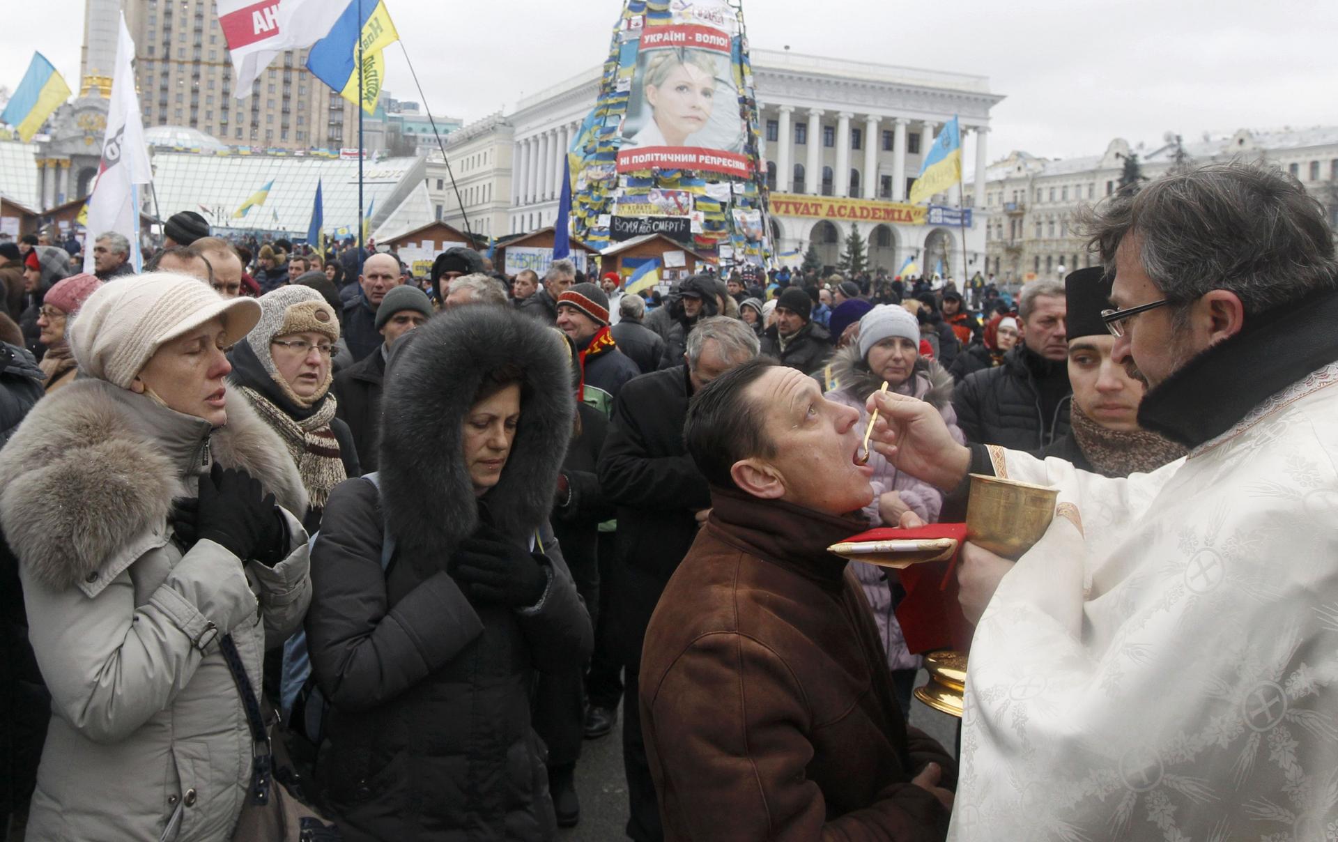 Protesters receive sacraments during a gathering organised by supporters of EU integration in central Kiev. Photo: Reuters