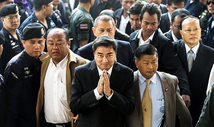 Abhisit Vejjajiva (centre) arrives at court yesterday. Photo: AFP