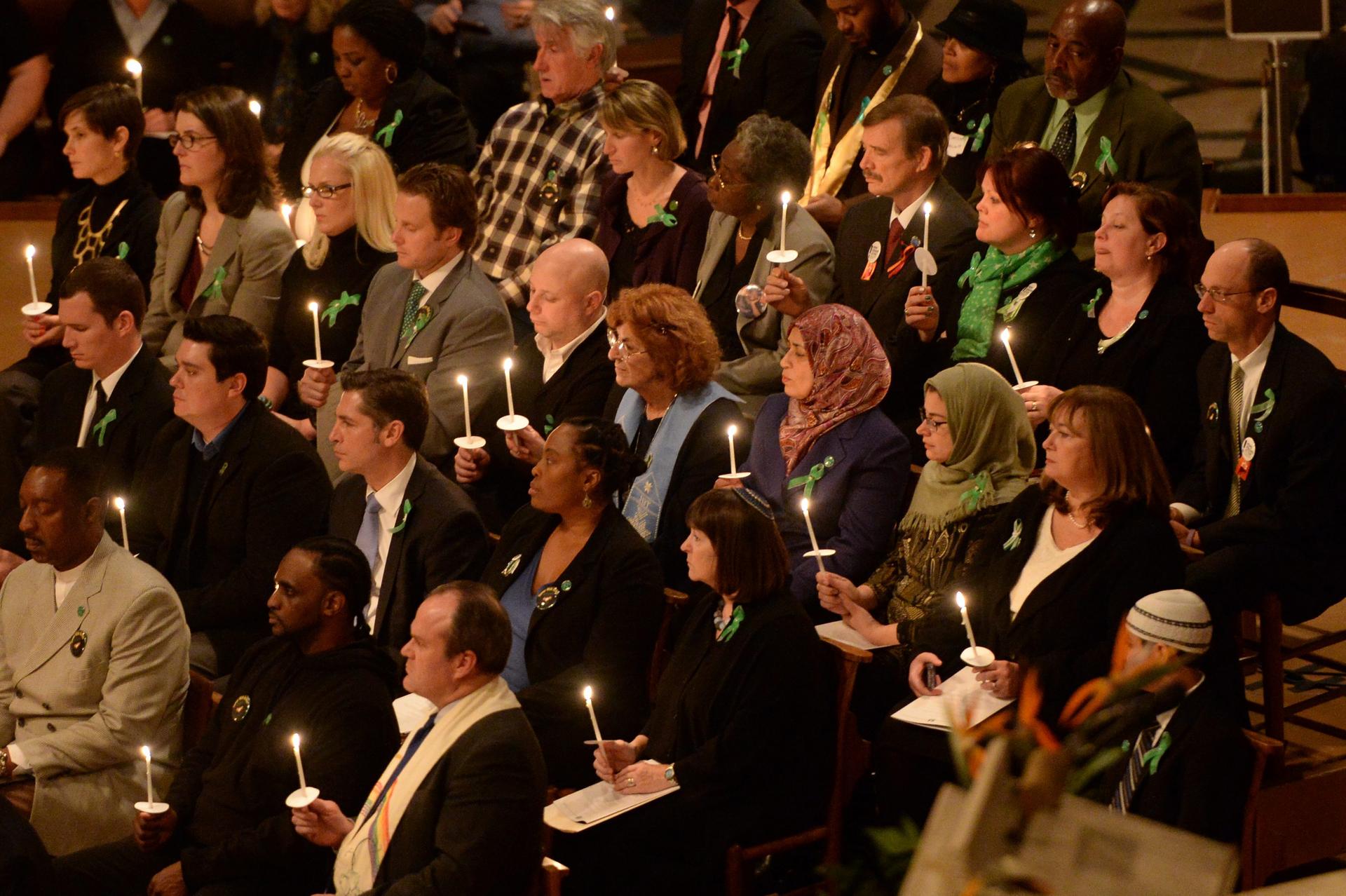 Congregation members hold lit candles during the vigil for victims of gun violence at Washington's cathedral on the eve of the anniversary of the Newtown shootings. Photo: EPA
