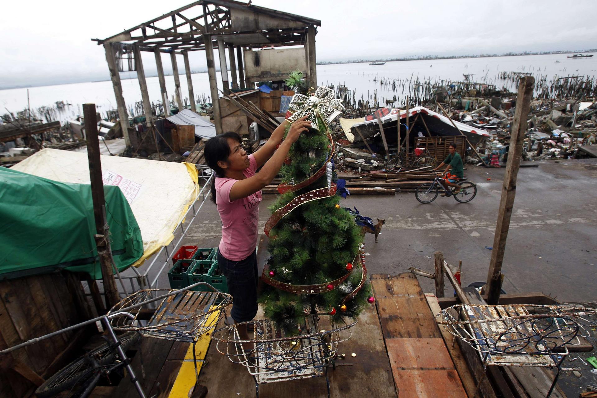 A woman decorates a tree in the devastated Sagkahan area of Tacloban as survivors do their best to celebrate Christmas. Photo: Reuters