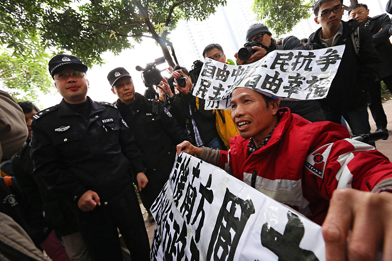 A pro-free-speech protester holds signs outside the headquarters of Nanfang Media Group in January. The company says the protests disrupted their operations. Photo: AFP