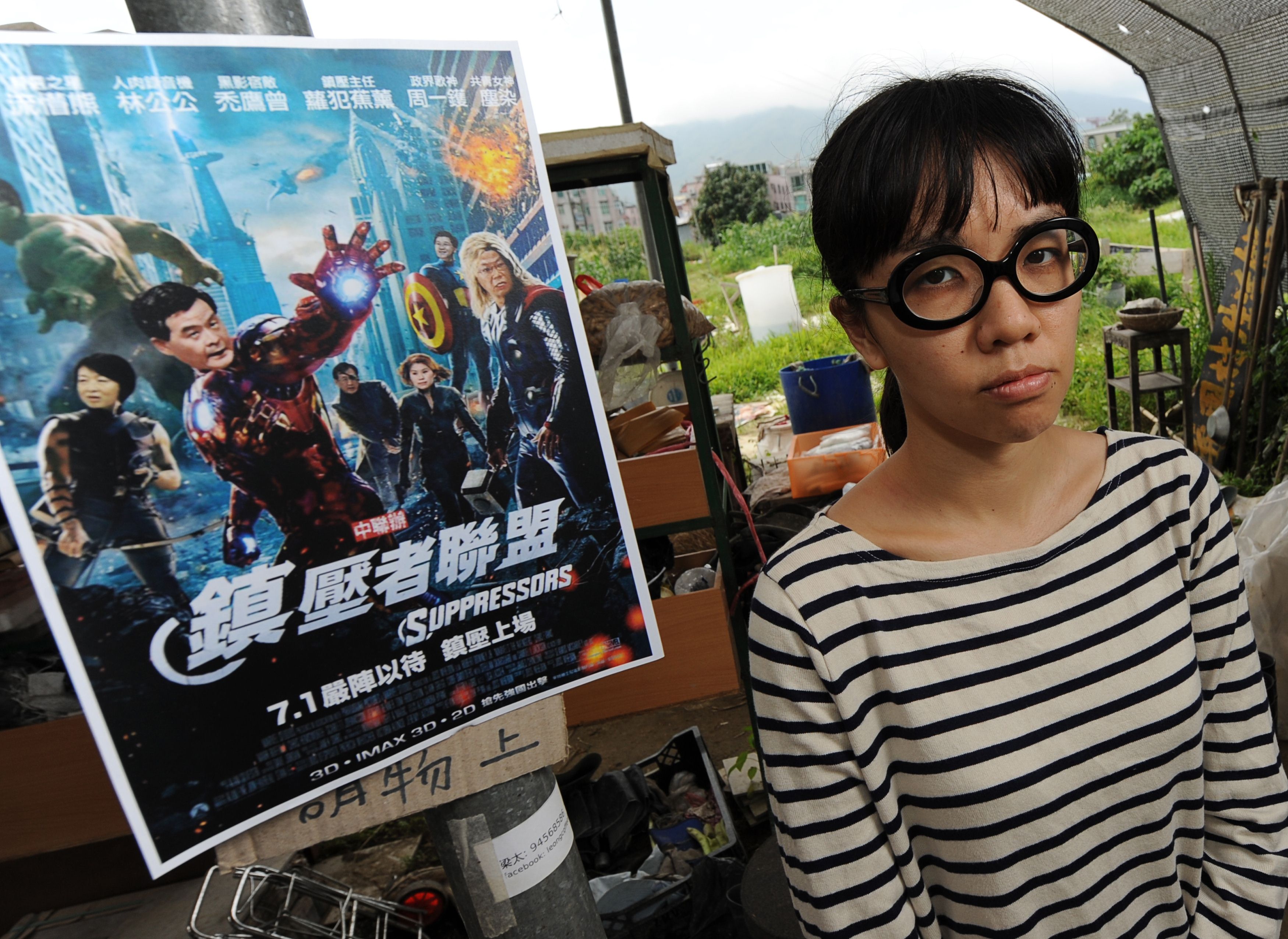 Political activist Ger Choi Tze-kwan stands next to a parody poster of movie The Avengers in May last year. 