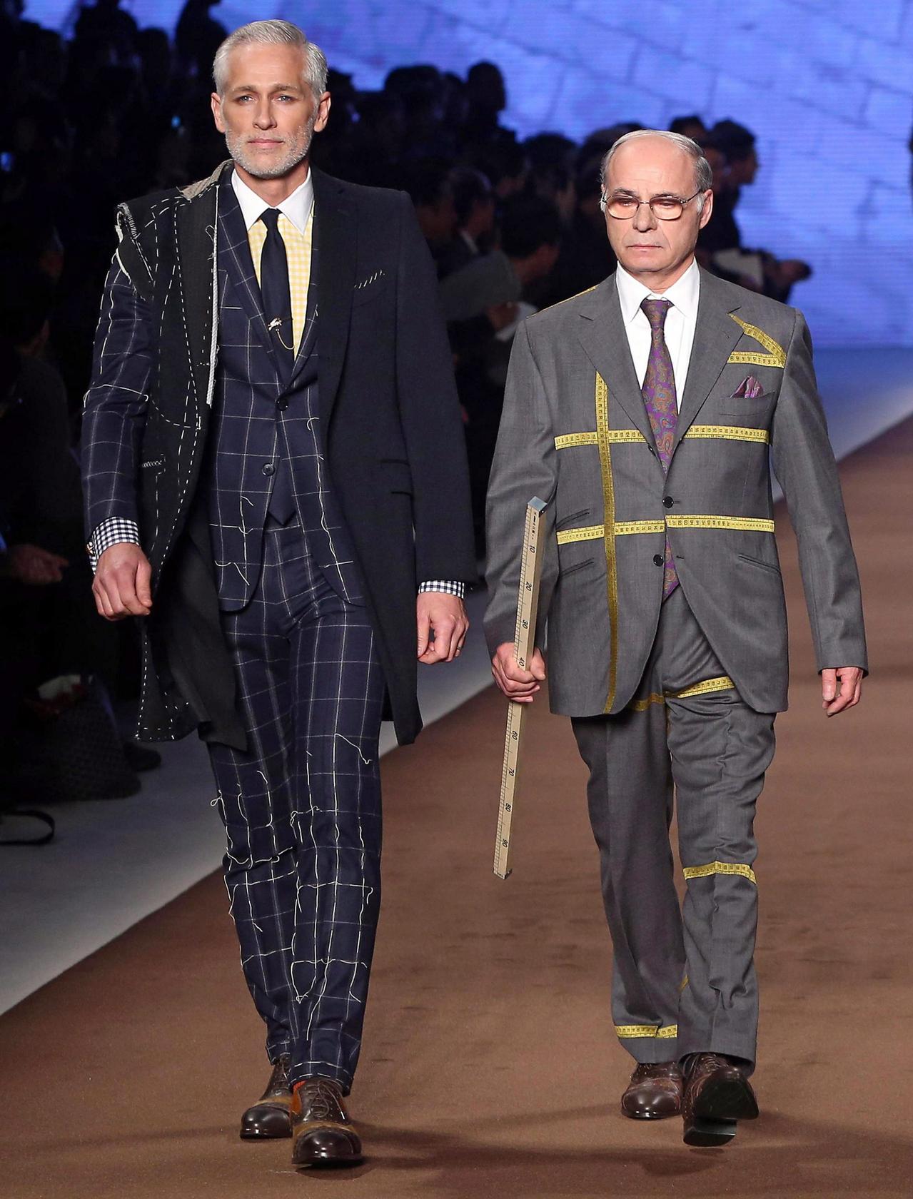 A model and a tailor from Etro on the catwalk.Photo: EPA