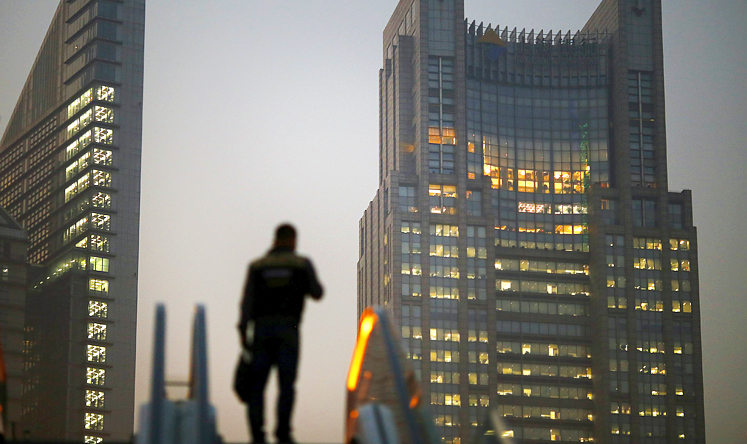 A man stands on an escalator in the financial district of Pudong in Shanghai in this November 20, 2013 file photo. Photo: Reuters