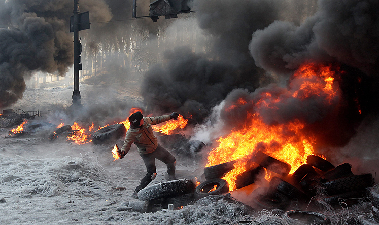 A protester throws a Molotov cocktail during an anti-government protest in Kiev on Saturday. Photo: EPA