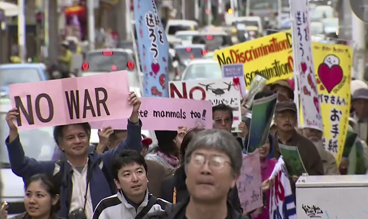 Protesters march against the relocation plan of the US base in Naha, Okinawa. Photo: AP