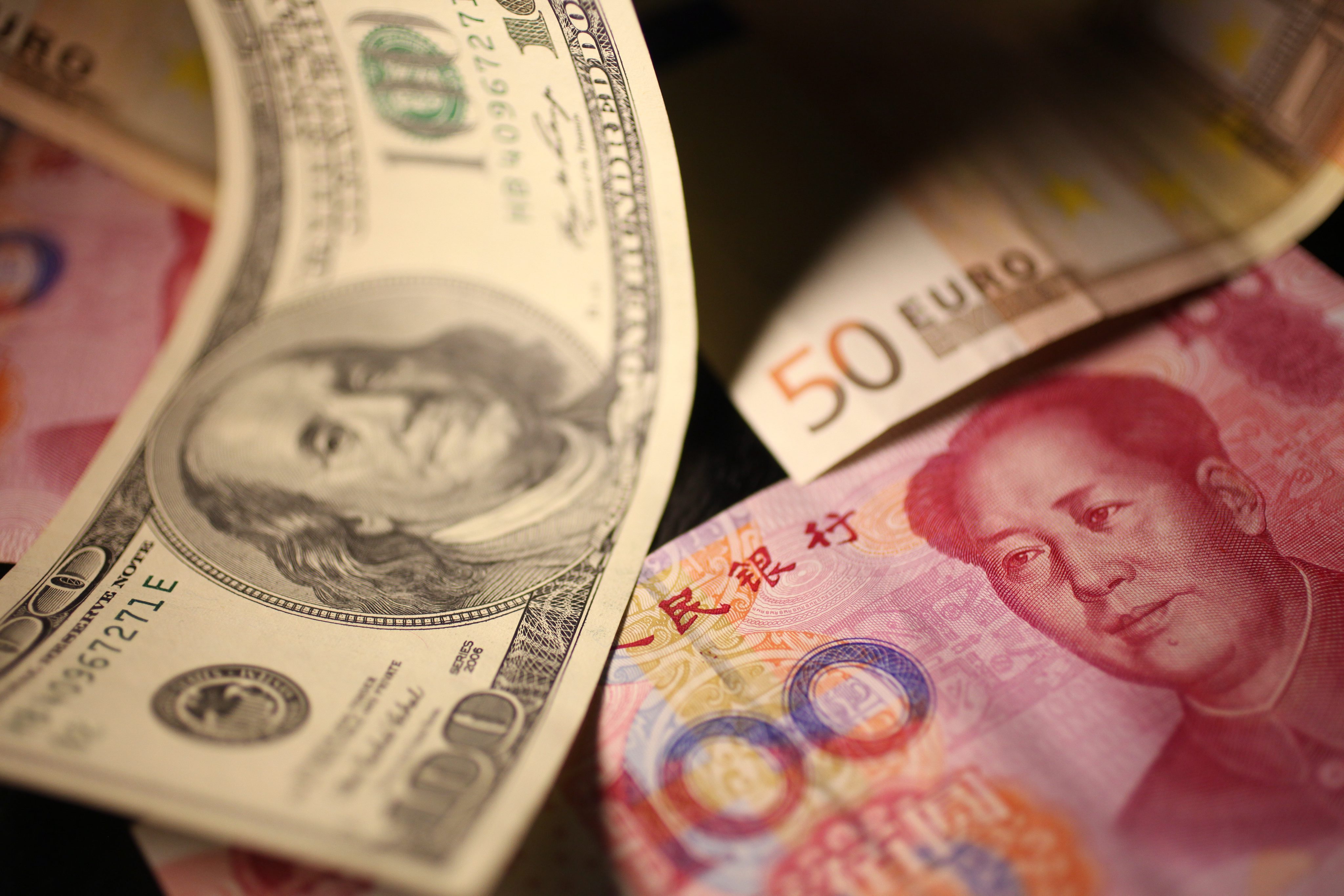 Chinese yuan or Renminbi, US dollar and euro banknotes seen in Beijing. Photo: EPA