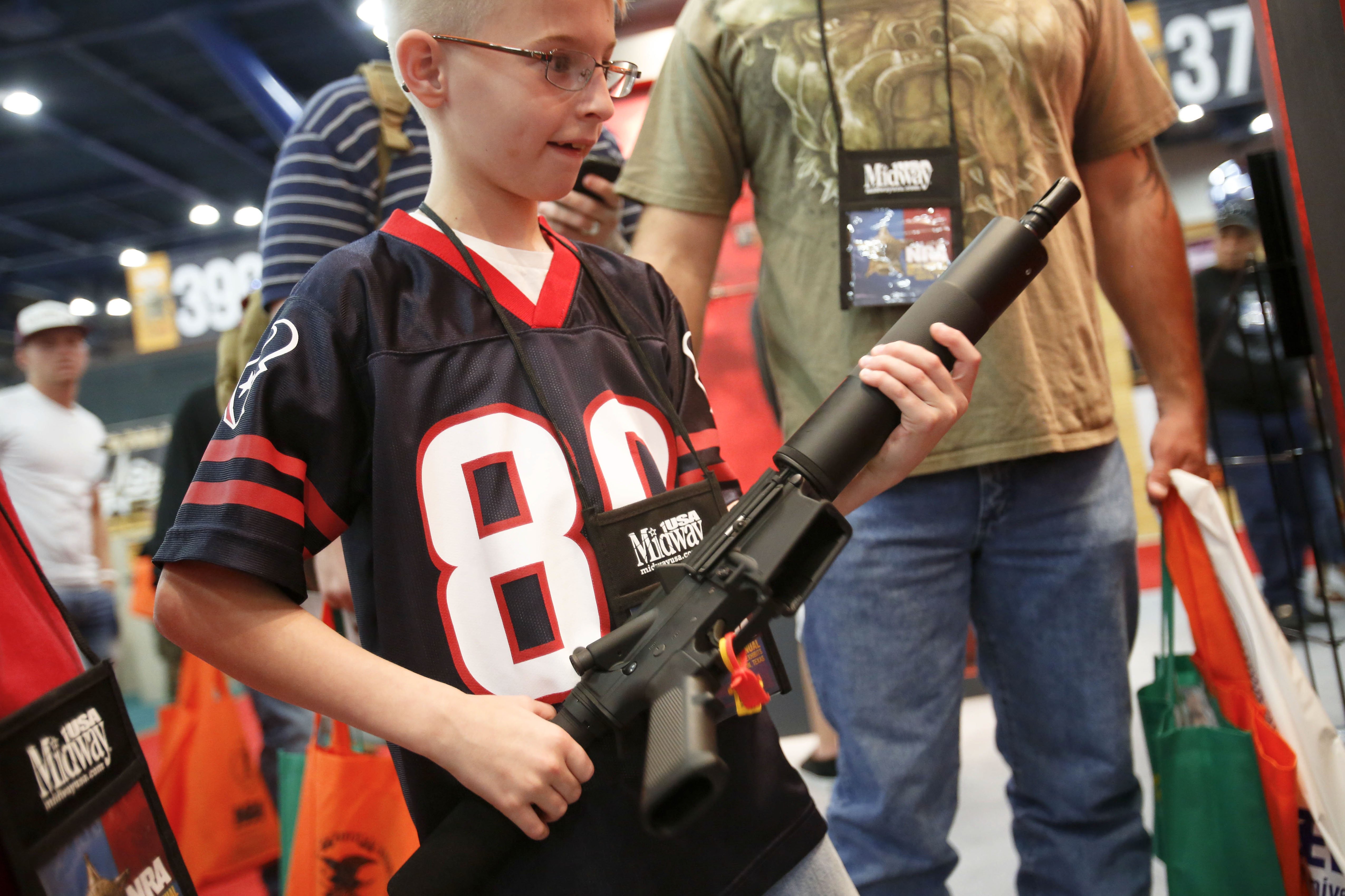 Tyler Rusch, 9, looks at an AR-15 style rifle on display during the National Rifle Association's annual convention last year. Photo: The New York Times