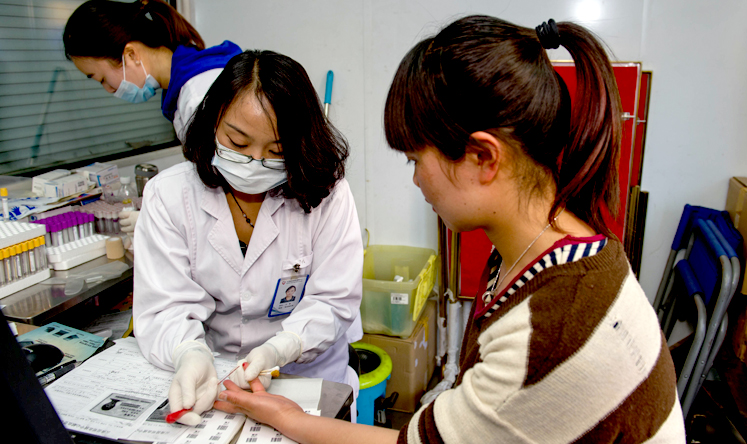 A woman undergoes a blood test before donating blood for Kunming victims. Photo: Xinhua