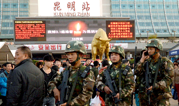 Chinese paramilitary police patrol outside the scene of the attack at the main train station in Kunming on Monday. Photo: AFP