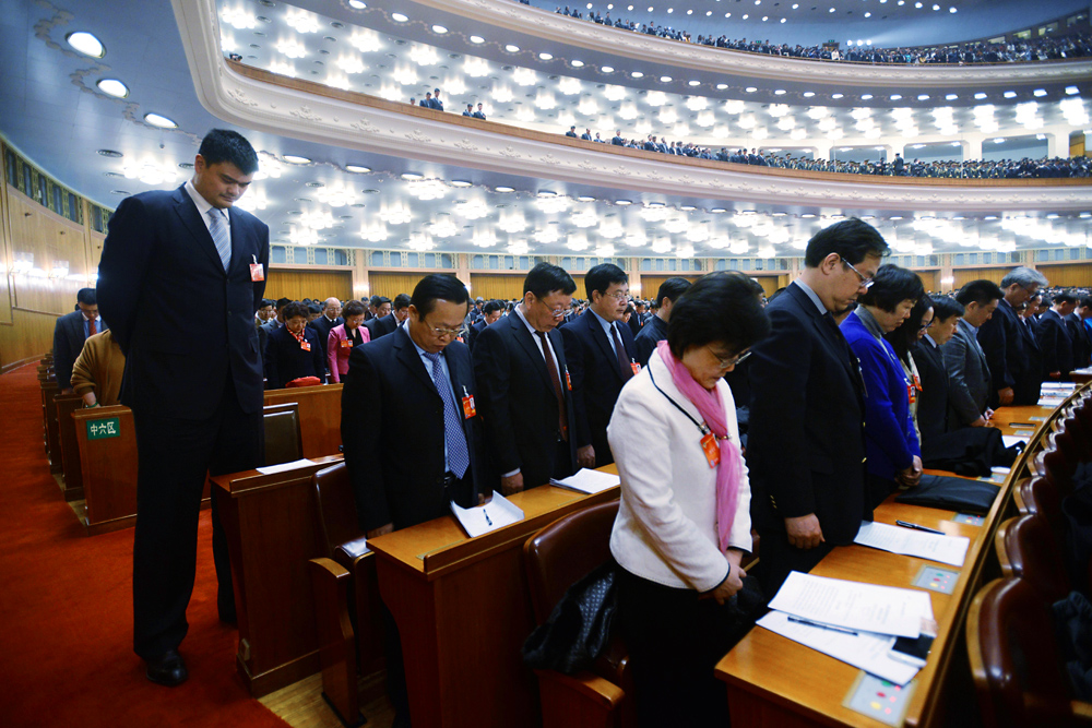 Basketball star Yao Ming, left, pays silent tribute to the victims of the Saturday terrorist attack in Kunming, with other delegates at the opening of the second session of the 12th National Committee of the CPPCC in Beijing on March 3, 2014. Photo: Xinhua