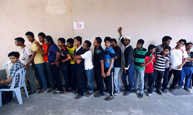 Rohingya men stand in a line at a centre to register for a temporary card issued by UNHCR in Kuala Lumpur. Photo: Reuters