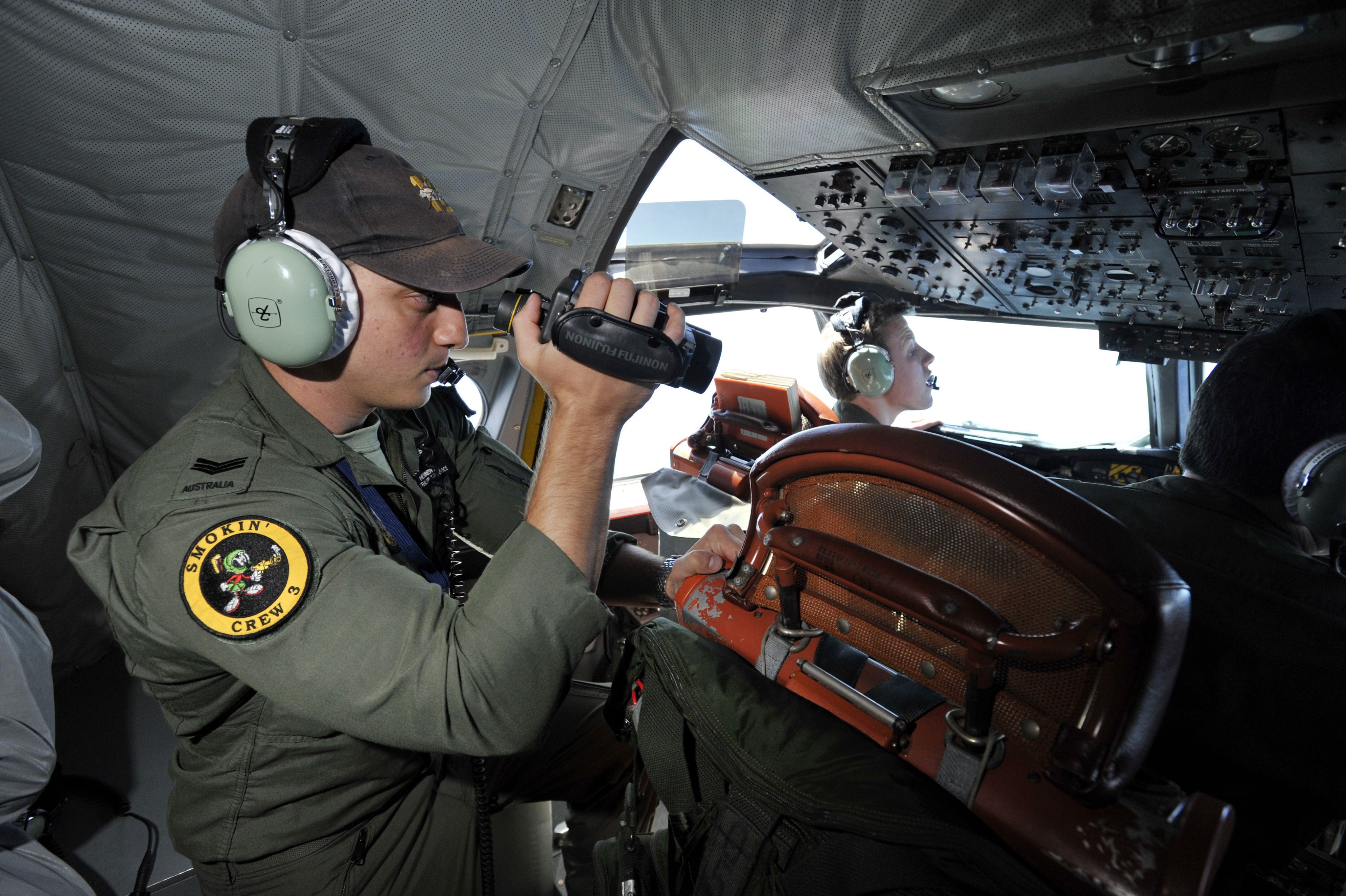 Royal Australian Air Force (RAAF) Seargent Ben Herbert searches an area some 2,500 kilometres southwest of Perth in the Indian Ocean this week. Photo: EPA