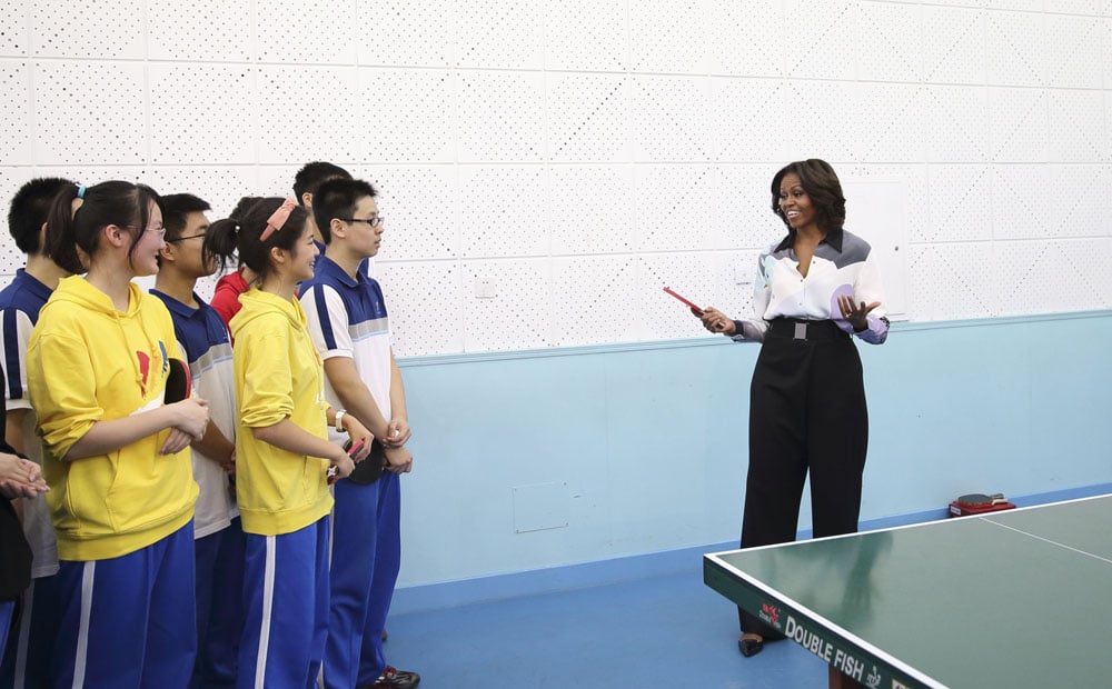 US First Lady Michelle Obama talks with students who practise table tennis while visiting the Second High School in Beijing. Photo: Xinhua