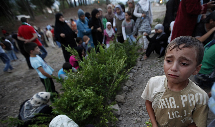 A Syrian refugee boy cries as he attends the funeral of five Free Syrian Army fighter. Photo: Reuters