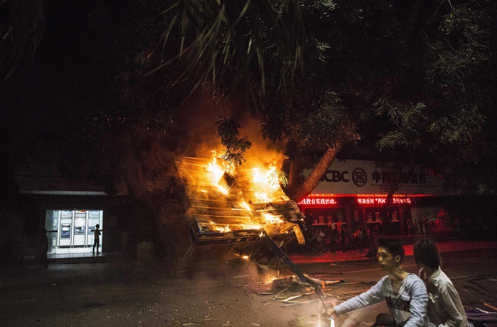 A police van burns in Maoming on Sunday. Photo: Reuters
