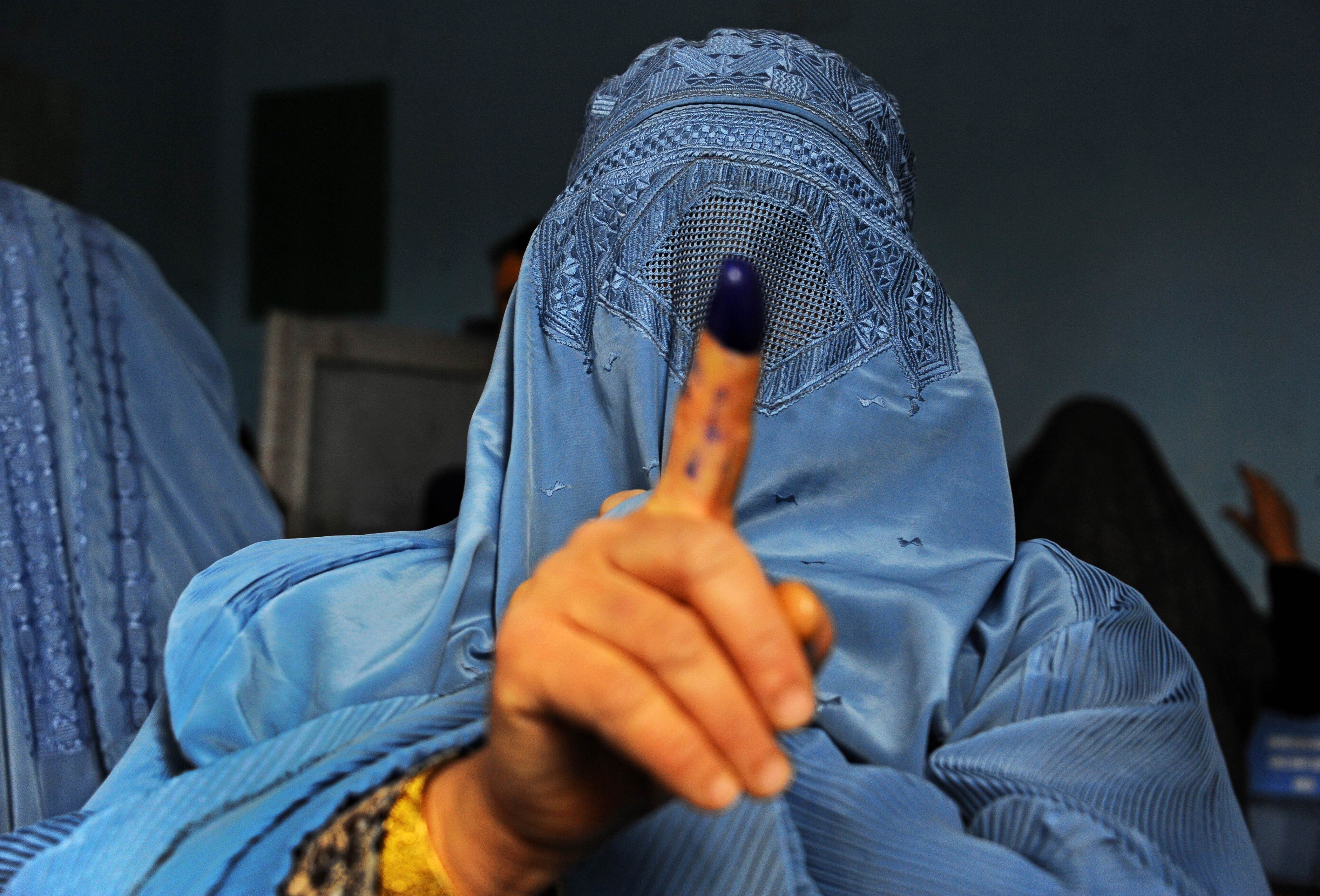 An Afghan woman shows her inked finger after voting at a polling station in the northwestern city of Herat on Saturday. Photo: EPA