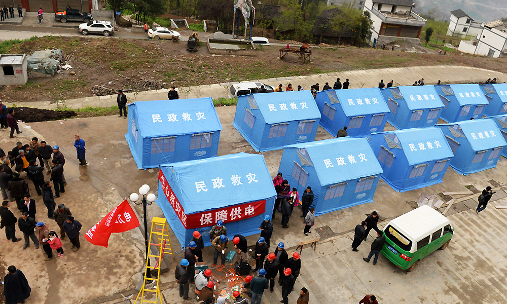 People stay at a settlement site in quake-hit Baisheng Village of Yongshan County. At least 21,000 relocated that struck the county early on Saturday. Photo: Xinhua