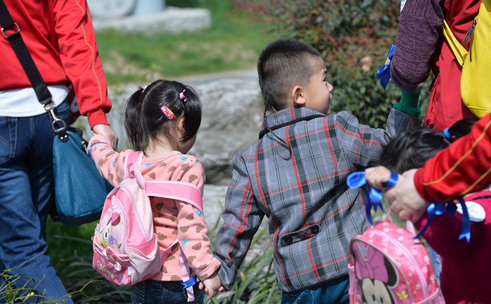 Volunteers and parents accompany autistic kids as they tour the Xuanwu Lake during a child welfare event in Nanjing. Photo: Xinhua