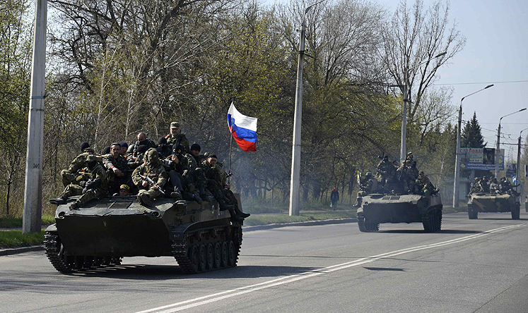 Armed men drive an airborne combat vehicle flying the Russian flag, outside Kramatorsk. Photo: Reuters