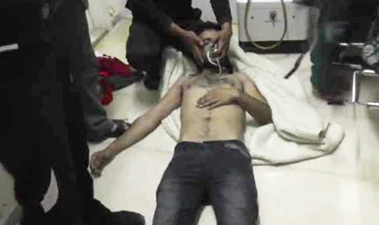 A man lies on the floor with an oxygen mask at a hospital room in Kfar Zeita, Syria on April 12. Photo: AP