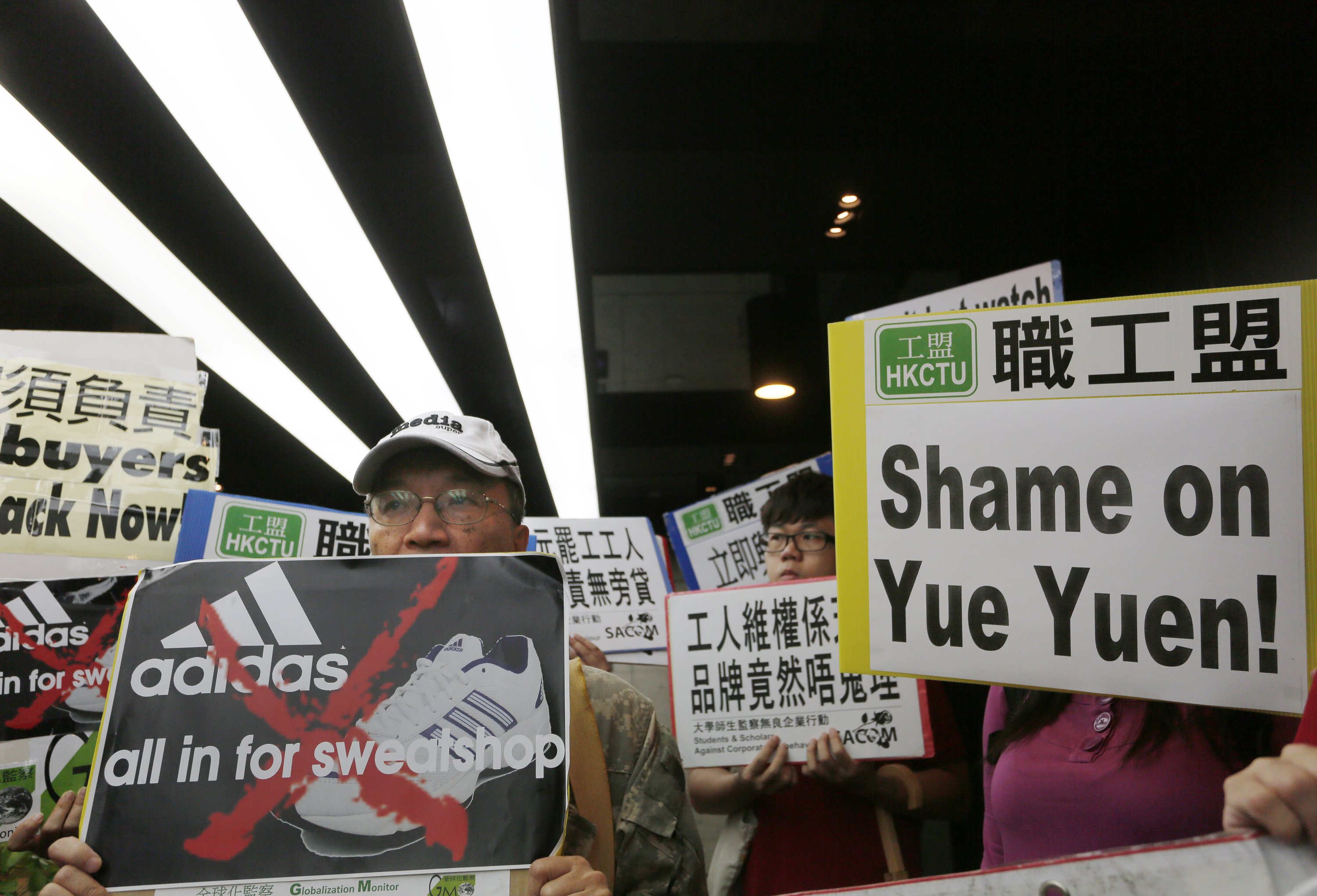 Protesters from labor organizations hold banners and placards during a protest to support workers on strike at Yue Yuen last week. Photo: AP