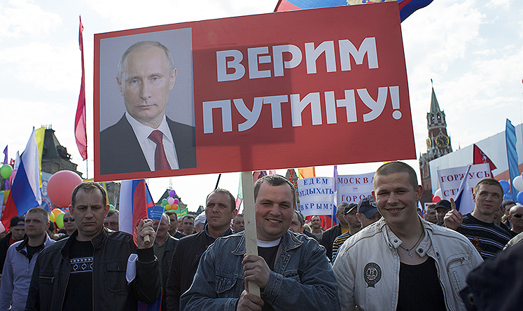 Muscovites march on May Day. The placards read: 'We Believe in Putin' (foreground) and 'We will spend our vacation in Crimea', (background). Photo: AP