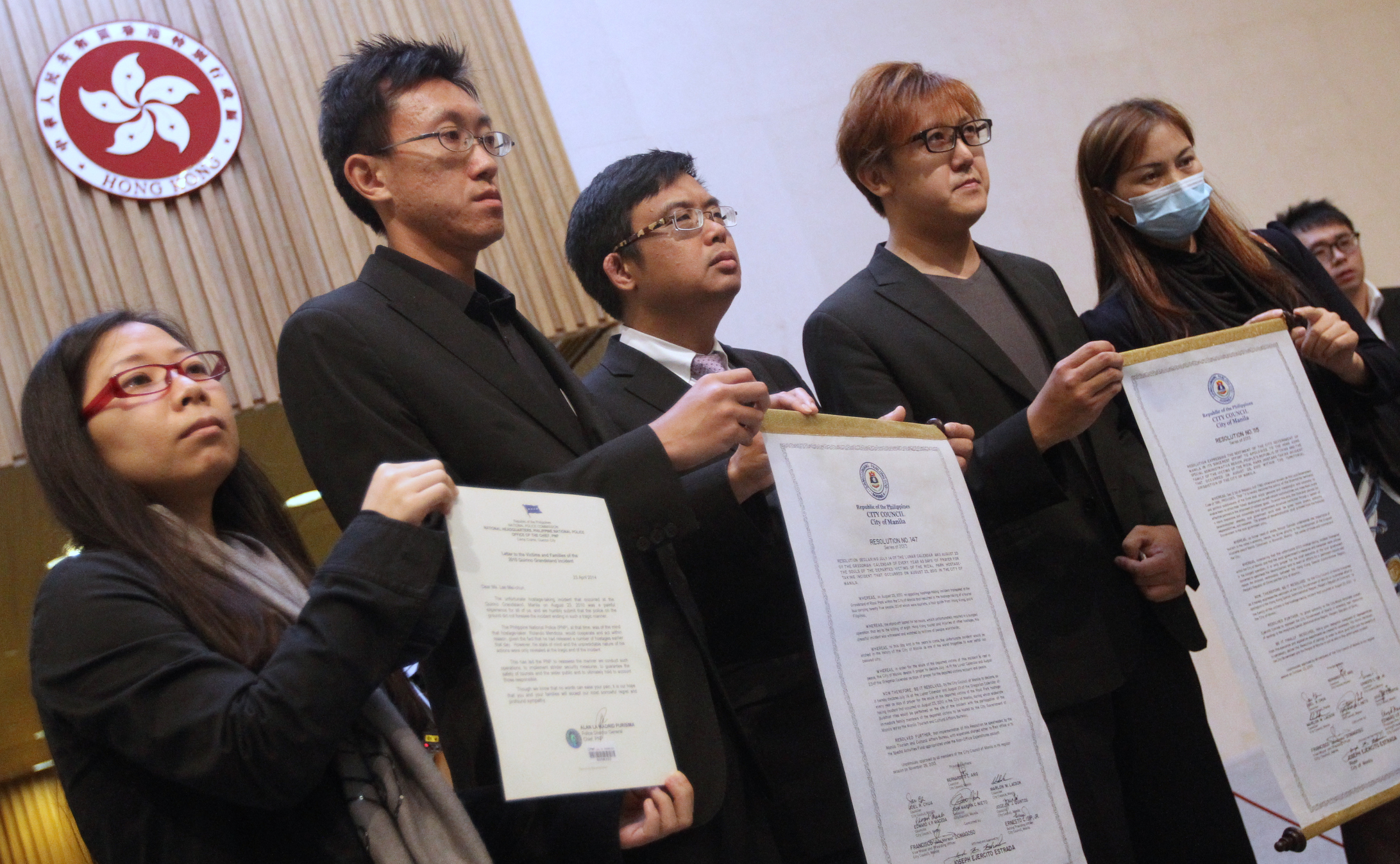 Survivor Lee Ying-chuen, deceased tour guide Masa Tse Ting-chunn's brother Tse Chi-hang, lawmaker James To Kun-sun, Tse's older brother Tse Chi-kin and survivor Yik Siu-ling with the resolutions from Manila city council and the letter from the police chief. Photo: Felix Wong