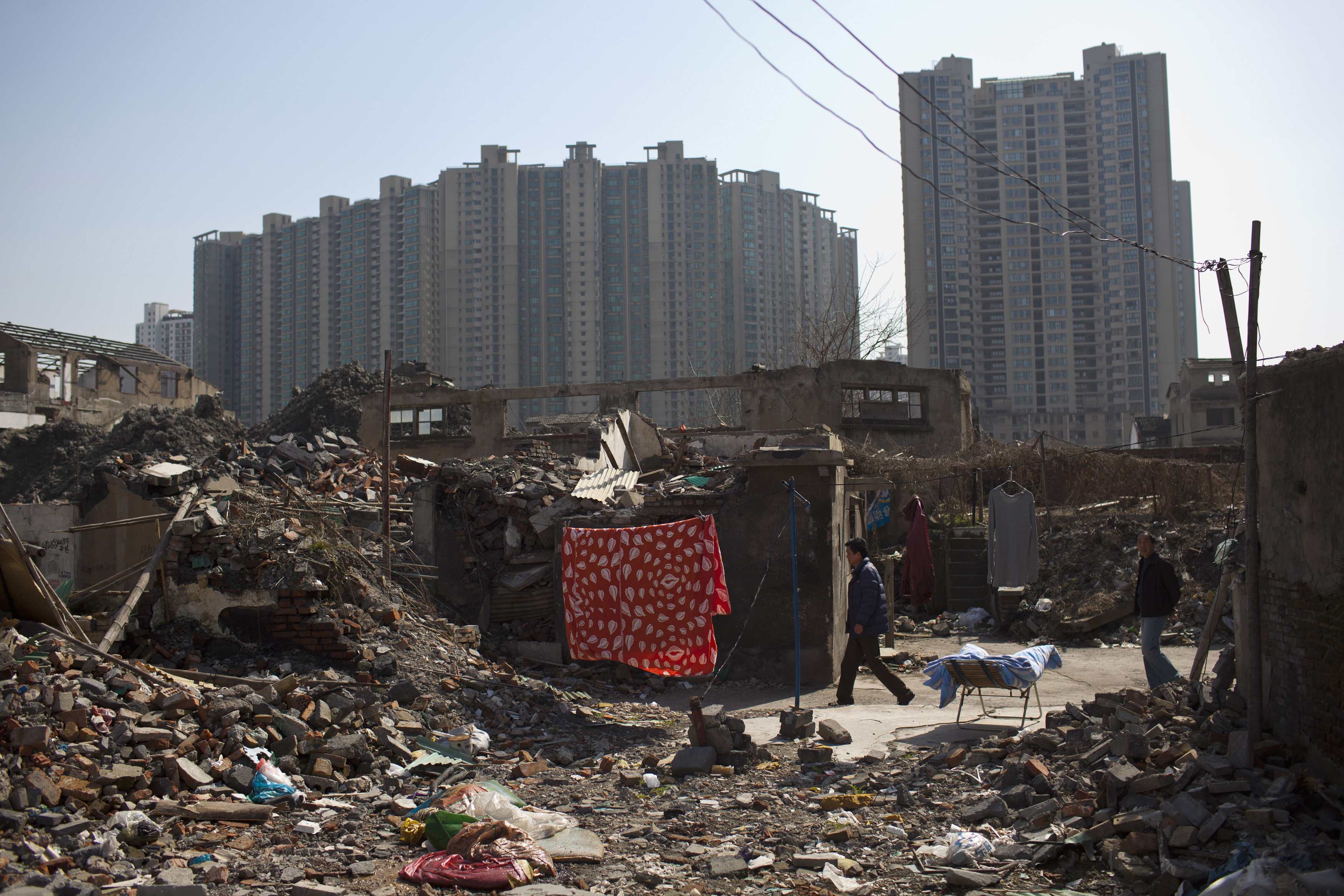 People walk in an area where residential buildings are demolished to make room for skyscrapers in Shanghai. Photo: Reuters