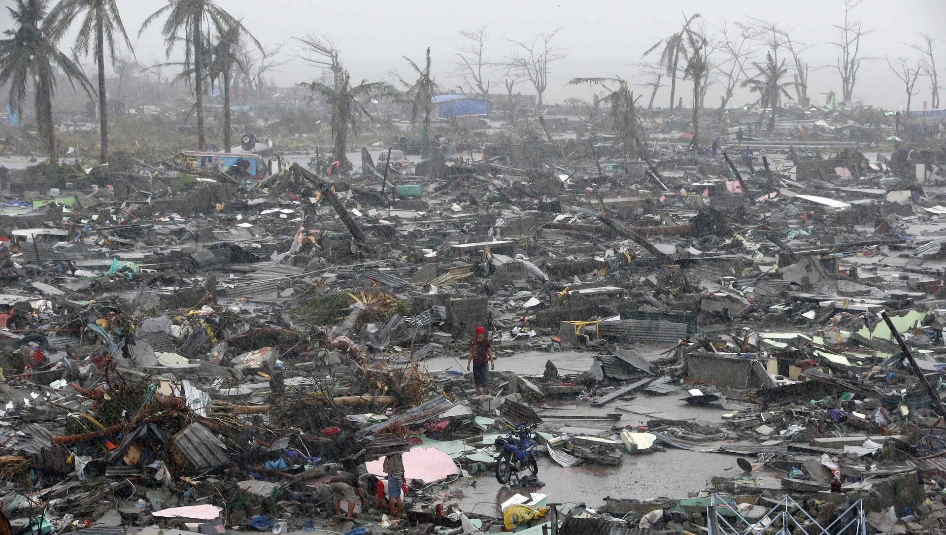 Devastation left by Super Typhoon Haiyan in Tacloban, with survivors stranded in the mud and rain amid debris from their homes against a bleak backdrop of wind-battered palm trees. Photo: Reuters